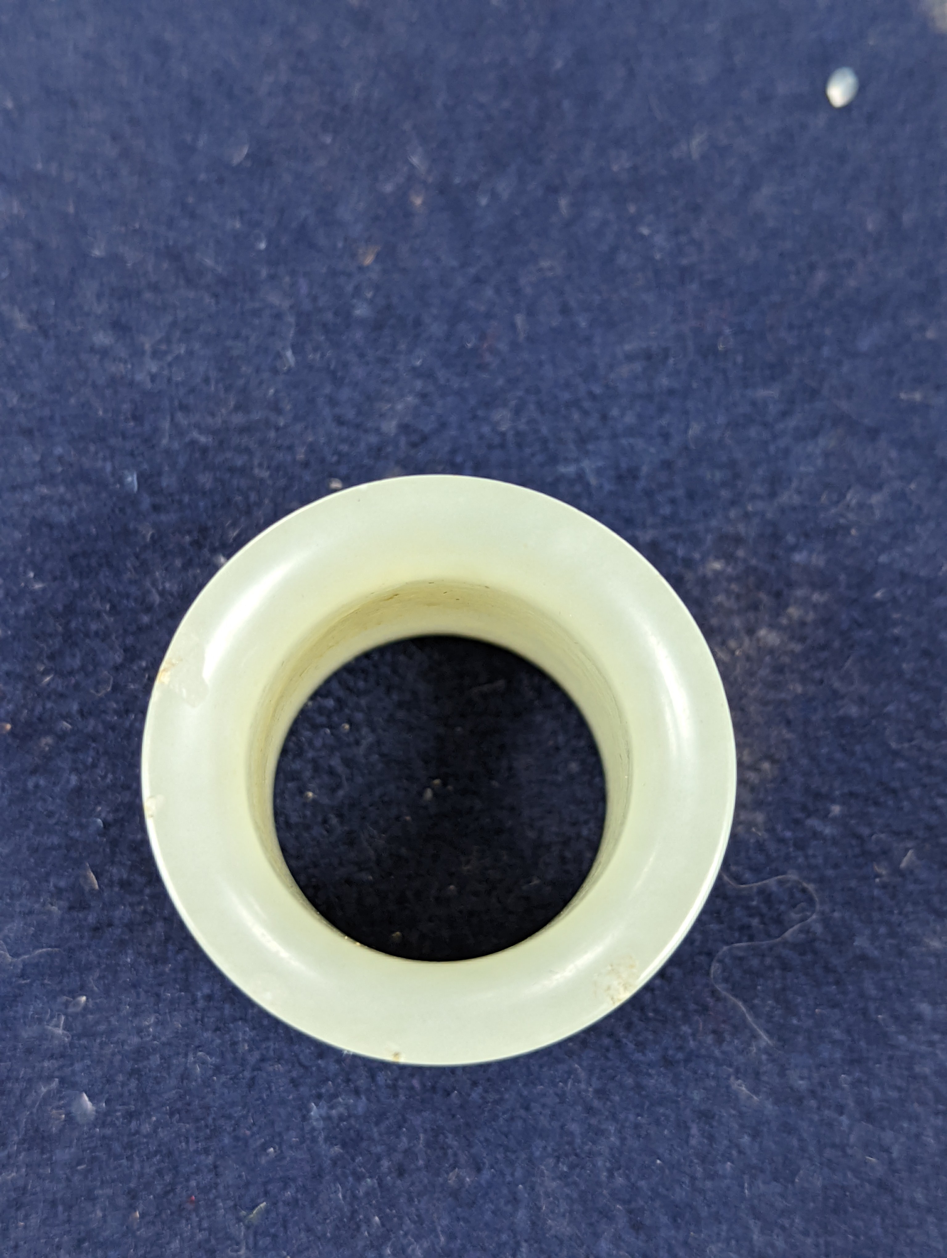 A 19th century Chinese pale celadon jade archer’s thumb ring, inscribed, 3 cm diameter